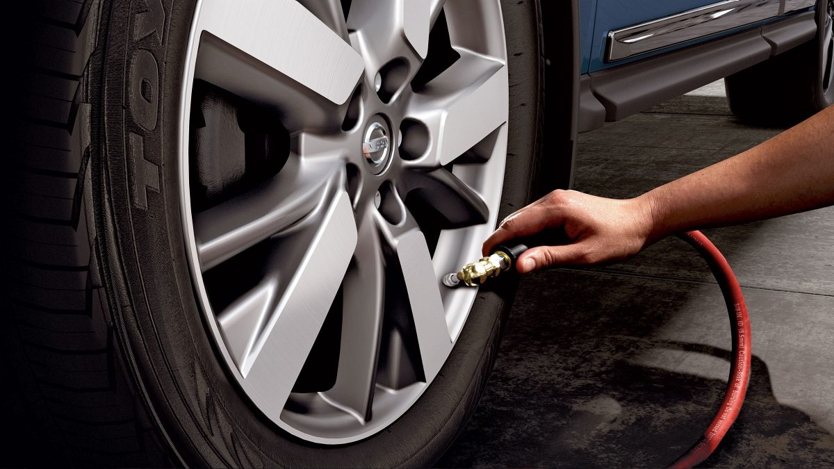 Nissan Pathfinder TPMS with Easy-Fill Tyre Alert with person filling up tyre